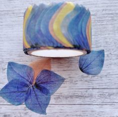 a blue and yellow flower sitting on top of a wooden table