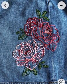 an embroidered rose on the back of a jean jacket, with buttons in each side