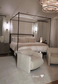 a bedroom with a bed, chair and chandelier hanging from it's ceiling