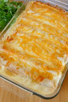 a casserole dish with cheese and vegetables in it on a wooden counter top