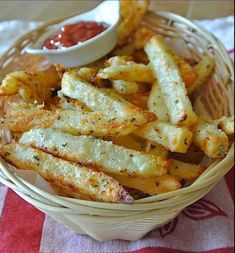 french fries with ketchup in a basket on a red and white tablecloth