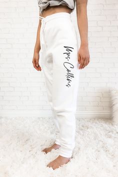 a woman standing on top of a white rug wearing sweat pants with the words no one else written on it