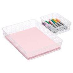 two plastic trays with pens and markers in them on a white background, one is empty