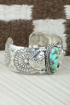 This Kingman turquoise and sterling silver bracelet was made by Navajo silversmith Emerson Delgarito. The inside is signed E. Delgarito and stamped sterling.Size: 5 5/8" (will fit up to a 6 1/2" wrist)Gap: 7/8"Length: 1 1/4"Free shipping on all orders! We ship with USPS and always include tracking. All orders ship within a day of payment.Returns are accepted up to 30 days after you receive your order. Just send us a message. Our shop offers cash back or store credit. The item must be returned in Stamped Turquoise Sterling Silver Bracelet, Stamped Sterling Silver Bracelet In Turquoise, Sterling Silver Turquoise Stamped Bracelet, Southwestern Etched Turquoise Jewelry, Southwestern Style Etched Turquoise Jewelry, Southwestern Turquoise Etched Jewelry, Southwestern Style Sterling Silver Turquoise Bracelet, Southwestern Stamped Turquoise Sterling Silver Bracelet, Southwestern Turquoise Stamped Sterling Silver Bracelet