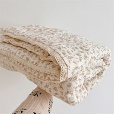 a stack of folded blankets sitting on top of each other in front of a white wall