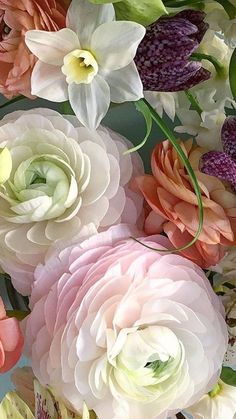 a bunch of flowers that are sitting in a vase on a table with other flowers