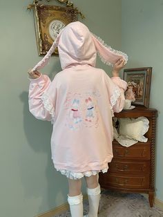 This hoodie is crafted from 100% cotton and features a loose fit, ensuring maximum comfort and coziness. The back of the printed version showcases an adorable bunny print, adding a touch of playful charm. The hoodie is designed with rabbit ear accents and delicate lace trim, enhancing its overall elegance. The sleeves and pocket edges are also adorned with lace details, creating a cohesive and stylish look. The side pockets are designed with a semi-closure to prevent items from falling out easil Cute Pink Hoodie For Loungewear, Cotton Cartoon Print Hoodie, Cute Pink Loungewear Hoodie, Cotton Kawaii Hoodie With Cartoon Print, Kawaii Cotton Hoodie With Cartoon Print, Kawaii Oversized Hoodie Top, Cute Long Sleeve Hoodie, Kawaii Style Oversized Hoodie Top, Oversized Kawaii Hoodie Top