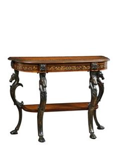 an ornate wooden table with metal legs and carvings on the top, against a white background