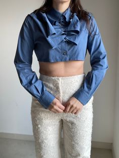 "1990s Romeo Gigli for Callaghan blue crop shirt with amazing work of jabot collar formed by the particular button closure, long sleeve 100% cotton Produced by Zamasport Marked size 42 (IT) Best fit: Small Made in Italy Condition: Excellent Measurements (taken flat): Shoulders: 41 cm / 16,1\" Armpit to armpit: 52 cm / 20,4\" Length: 35 cm / 13,7\" -- -- CONDITION GLOSSARY -- -- DEADSTOCK: the item is new, never be worned and it still has the label tag. EXCELLENT: the item is like new, it has no Fitted Long Sleeve Cropped Shirt For Spring, Elegant Fitted Cotton Cropped Shirt, Blue Fitted Cotton Cropped Shirt, Fitted Blue Cotton Cropped Shirt, Blue Fitted Top With Ruffled Collar, Blue Cotton Tops With Ruffled Collar, Elegant Long Sleeve Cropped Shirt For Fall, Fitted Blue Cropped Shirt, Long Sleeve Cropped Shirt With Buttons For Fall