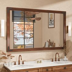 a bathroom with two sinks and a large mirror over the sink that's hanging on the wall