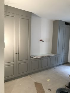 an empty room with gray cabinets and white walls