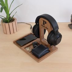 a wooden stand with headphones, wallet and cell phone in it on a table