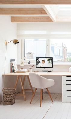 a home office with white furniture and wood beams on the ceiling, along with a large window