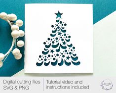 a christmas tree cutout on top of a card next to some white balls and string