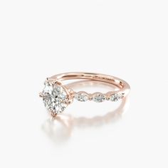 a rose gold engagement ring with an oval cut diamond in the center and side stones