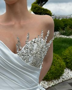 a woman in a white dress with a tiara on her head and one shoulder