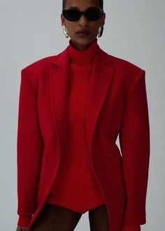 a woman in a red suit and sunglasses