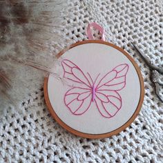 a close up of a embroidery on a piece of cloth with scissors and yarn in the background