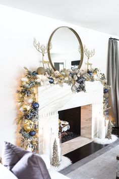 a living room decorated for christmas with gold and silver decorations on the fireplace mantel