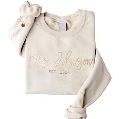 a white sweater with the name mrs johnson on it and a bow at the neck