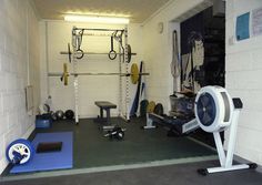 the inside of a home gym with equipment on the floor and in the garage area