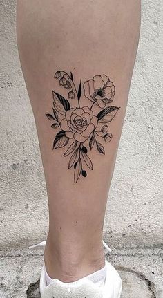 a woman's foot with flowers on it and the bottom part of her leg