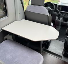 the interior of a vehicle with a table and chairs in it, next to an open window