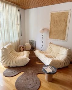 a living room with two chairs and a rug on the floor