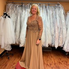 a woman standing in front of some dresses