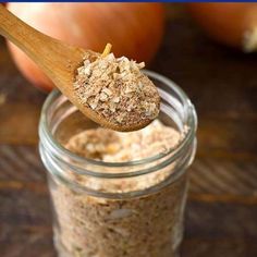 a wooden spoon with some food in it on top of a glass jar filled with oatmeal