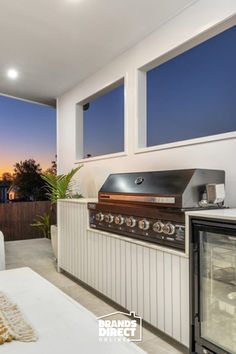 an outdoor kitchen with grill and seating area