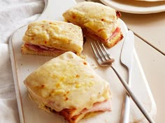 ham and cheese biscuits on a cutting board with a fork next to it