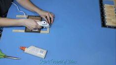 a person is using scissors to cut out paper with glue and other crafting supplies