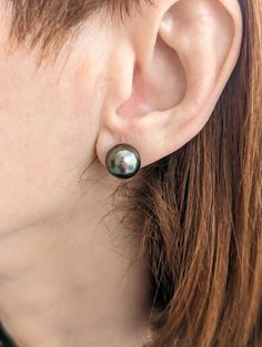 These are exceptional Tahitian pearl stud earrings. The pearls are mounted on 14K yellow gold posts and backings, which are appropriately sized and medium-weight. The pearls' size is 10-11mm, and the total weight is 4.6g. They are perfectly round with a dark gray color and prominent blue overtone. The surface is clean and the luster is high, making them perfect for everyday wear. These earrings are a very beautiful pair that will add elegance to any outfit. Each piece of our jewelry is unique an Tahitian Pearl Earrings Studs, Unique Studs, Tahitian Pearl Necklace, Stud Earrings Unique, Dark Gray Color, Dark Grey Color, Tahitian Pearls, Vintage Pearls, Pearl Stud Earrings