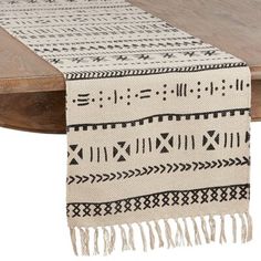 a table with a white and black rug on it's side next to a wooden table