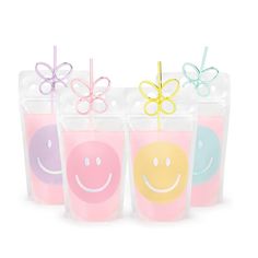 four plastic cups with smiley faces and bows on the top one is filled with liquid