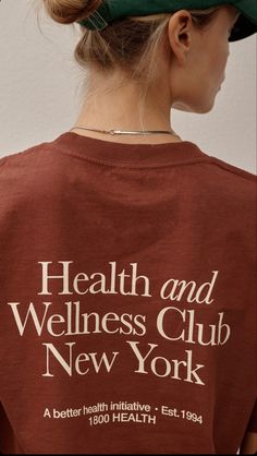 a woman wearing a t - shirt that says health and wellness club new york