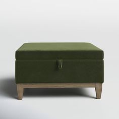 a green ottoman sitting on top of a wooden table