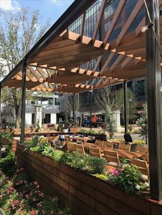 an outdoor seating area with wooden benches and flowers