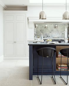 two stools sit at the center of a kitchen island