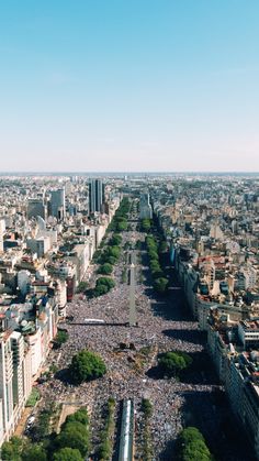 a large group of people standing in the middle of a city