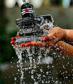 a hand holding a water spigot that is pouring out of it