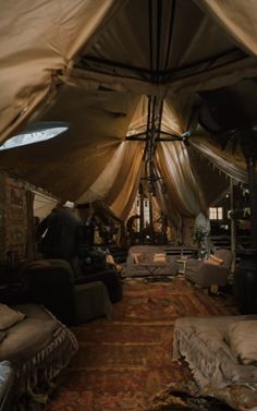 the inside of a tent with couches and chairs