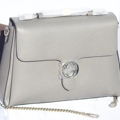 The Gucci Large Top Handle Interlocking Gg Crossbody In Gray Is Crafted From Dollar Calf, Pebbled Leather In Italy. This Bag Has A Large Construction With Walls Going Inward To A Trapezoid Shape. It Features An Interlocking Gg Clasp, Top Handle, Removable And Adjustable Leather Shoulder Strap, And 2 Interior Compartments. Gray Large Top Handle Interlocking Gg Crossbody Gold-Tone Hardware (Gentle Cold With Silver Hues) 100% Dollar Calfskin Leather Large Shoulder, Crossbody Bag Top Flap With Magne Designer Silver Gucci Bags, Silver Gucci Evening Bag, Designer Gucci Silver Bag, Chic Gucci Bag With Silver-tone Hardware, Gucci Diaper Bag, Gucci Dionysus Super Mini, Gucci Shoulder Bag With Silver-tone Hardware For Daily Use, Dionysus Super Mini Bag, Gucci Bag With Silver-tone Hardware