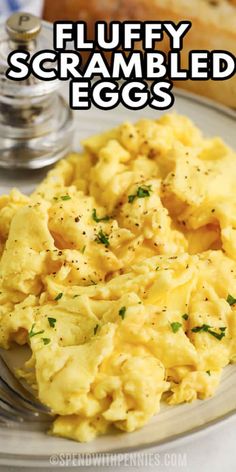 scrambled eggs on a white plate with a fork and bread in the background text reads perfect scrambled eggs