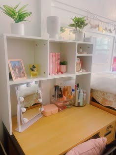 a wooden desk topped with a mirror next to a shelf filled with makeup and other items