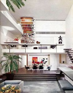 a living room filled with lots of furniture and bookshelves on top of it