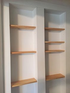 two empty shelves in the corner of a room