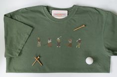 Olive green Comfort Colors shirt with neutral-colored minimal golfers embroidered on the front (10x2in) and a golf hole (1.5in) embroidered on the back below the collar. Cotton Golf Tops, Green Crew Neck Top For Golf, Green Cotton Golf T-shirt, Green Cotton T-shirt For Golf, Green Cotton Golf Tops, Green Cotton Tops For Golf, Embroidery Tshirt, Golf 1, Comfort Colors Shirt