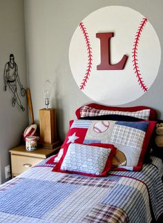 a baseball themed bedroom with the letter l on it's headboard and pillows